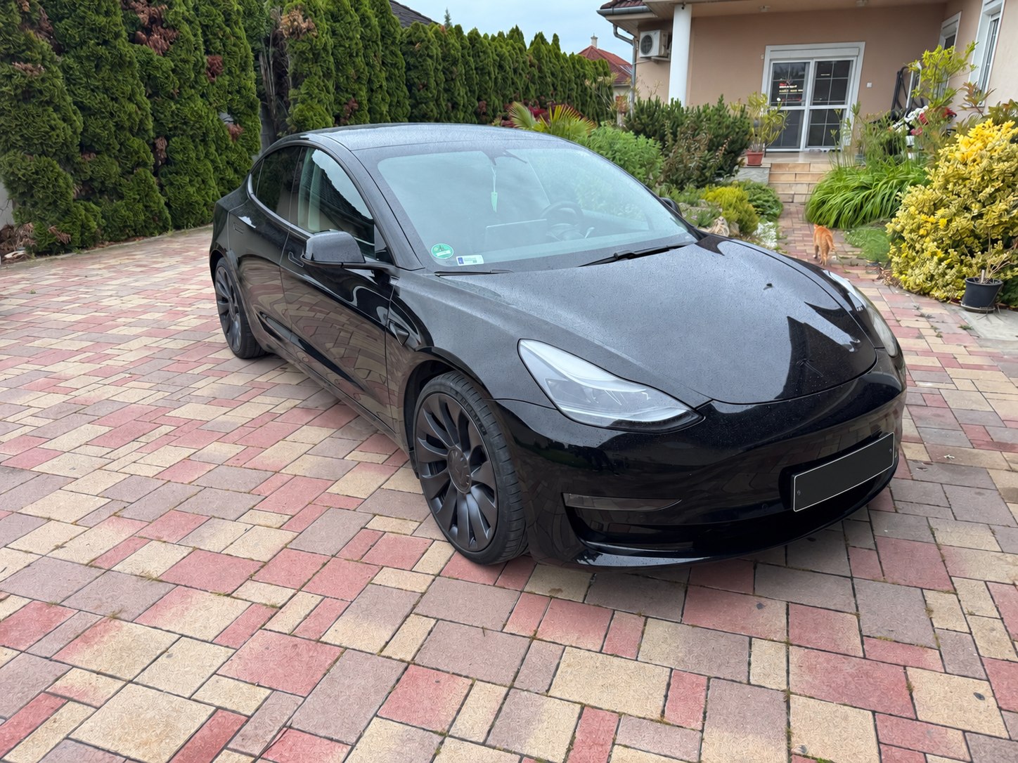 Fekete Tesla Model 3 külső állapotfelmérésen, anonimizált rendszámmal