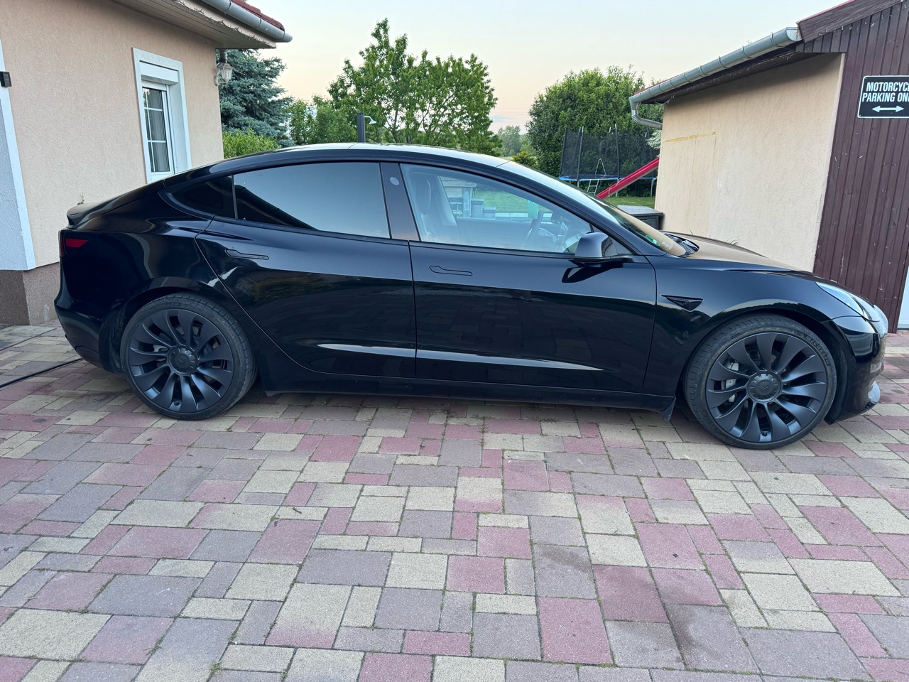 Fekete Tesla Model 3 teljes oldalnézetből